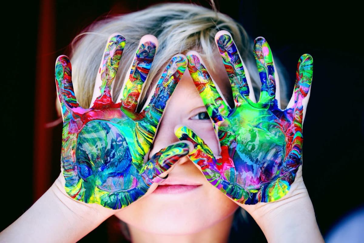 A child's hands covered in paint